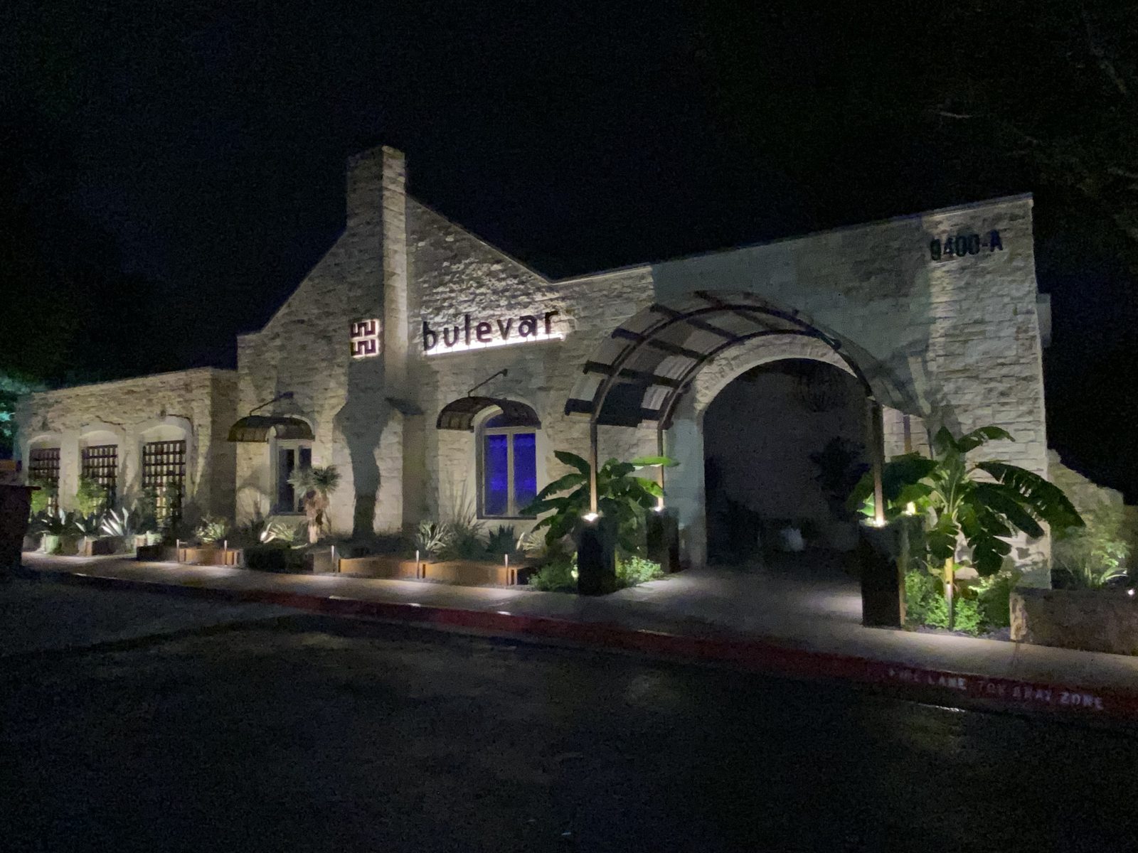 Bulevar Mexican Kitchen exterior at night with stone facade and warm lighting