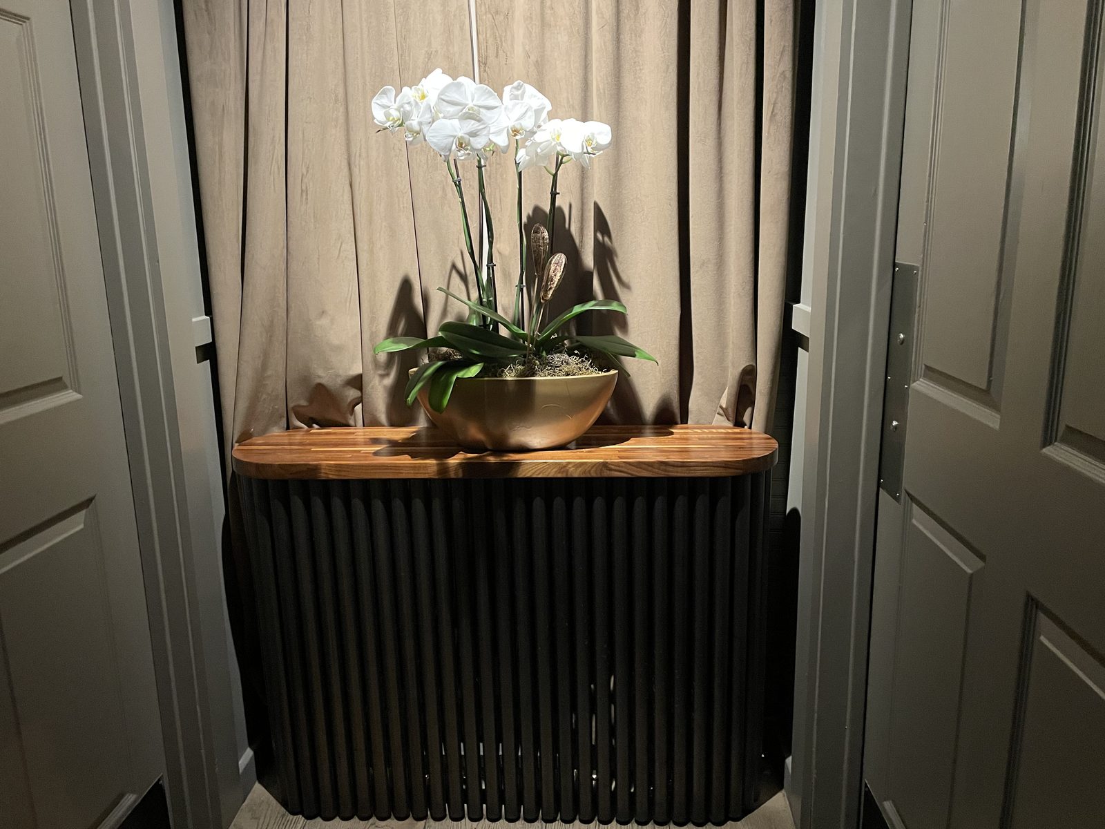 Fluted dark-wood host stand with orchids