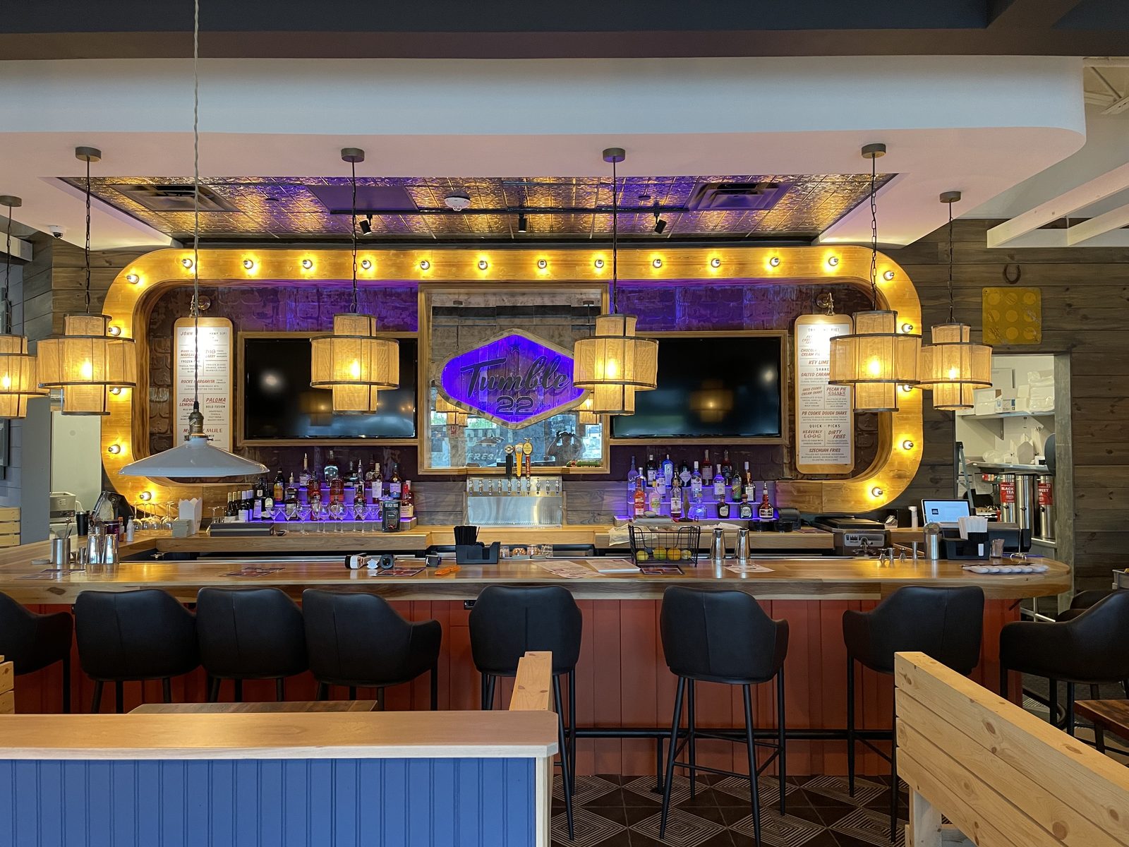 Bar with illuminated back-bar display and blue stools